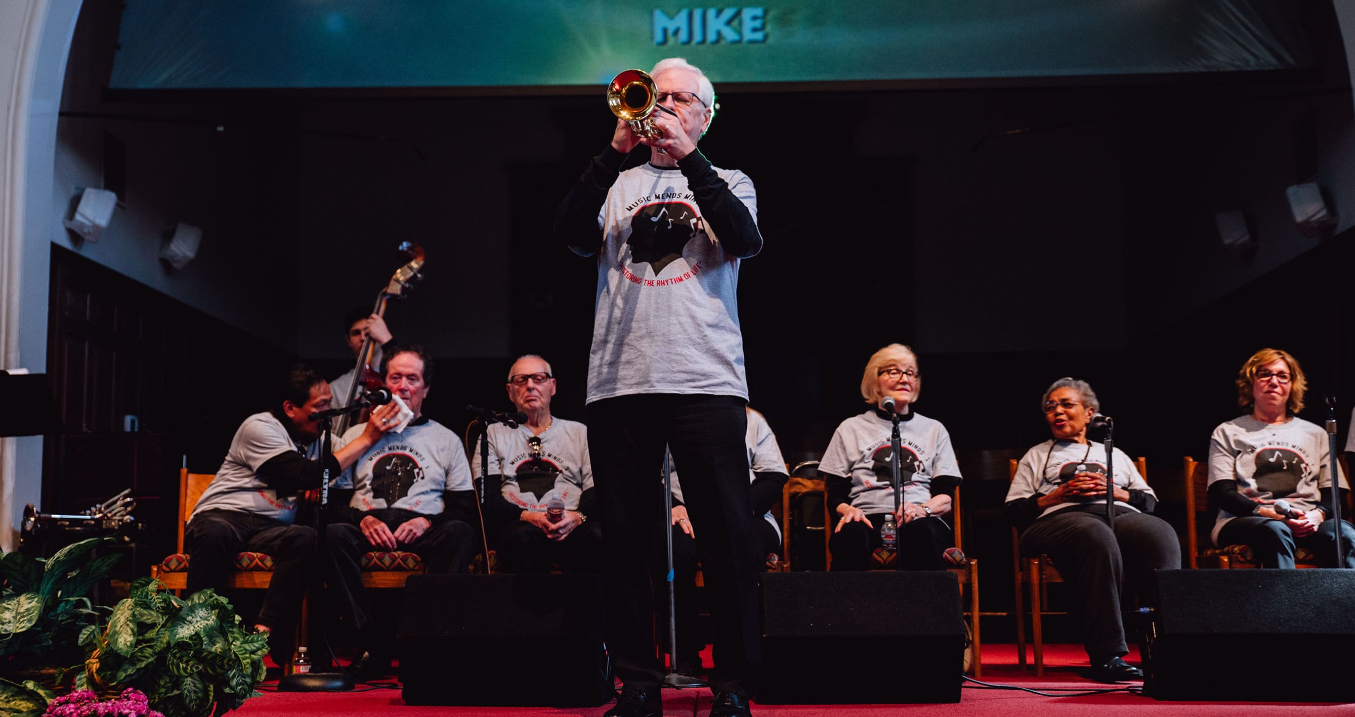 Music Mends Minds musicians performing together, with a trumpet player at center stage
